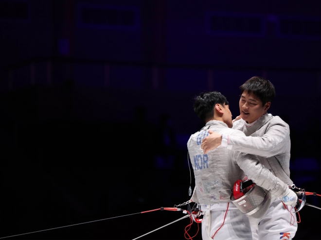 25일 중국 항저우 전자대에서 열린 2022 항저우아시안게임 펜싱 남자 사브르 개인전 결승에서 우승을 차지한 오상욱(오른쪽)과 구본길이 포옹하며 인사를 나누고 있다. 항저우 연합뉴스