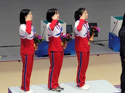 사격 여자 10m 러닝타깃 단체전에서 이번 대회 첫 금메달을 딴 북한 여자 사격 대표팀이 시상식에서 거수경례를 하고 있다.