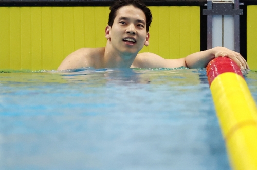 남자 배영 200m 결승에서 한국 신기록으로 은메달을 딴 이주호가 전광판을 보며  웃고 있다.