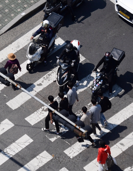 서울 관악구 신림역 사거리에서 배달 오토바이들이 정지선을 넘어 건널목까지 침범해 보행자들을 위협하고 있다. 서울신문DB