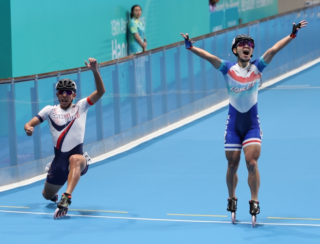 지난 2일 중국 항저우 첸탕 롤러스포츠 센터에서 열린 2022 항저우 아시안게임 롤러스케이트 남자 스피드 3000m 계주 결선에서 한국 마지막 주자 정철원(오른쪽)이 피니시라인을 통과하며 세리머니를 하고 있다. 결과는 은메달.