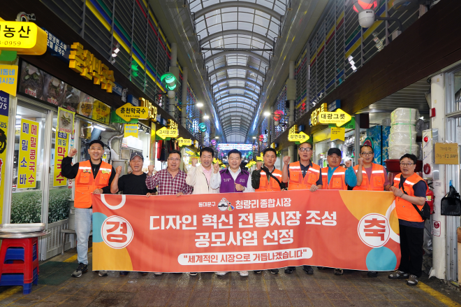 이필형(왼쪽 다섯 번째) 서울 동대문구청장이 청량리종합시장에서 상인들과 함께 서울시 디자인 혁신 전통시장 조성 공모사업 선정을 축하하며 파이팅을 외치고 있다. 동대문구 제공