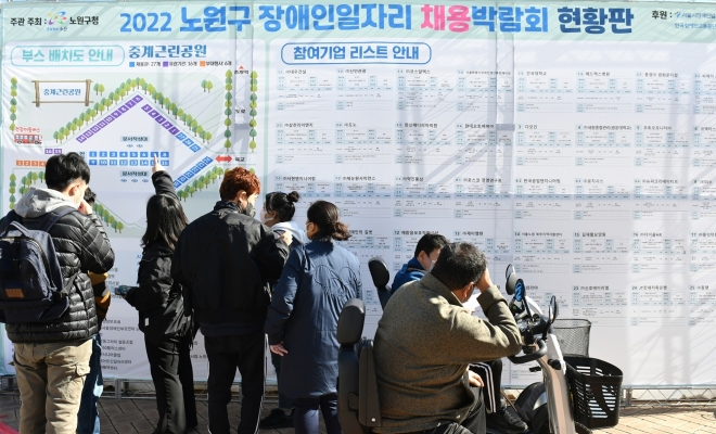 지난해 서울 노원구가 연 ‘장애인 일자리 채용 박람회’를 찾은 구민들이 채용 기업 목록을 보고 있다. 노원구 제공