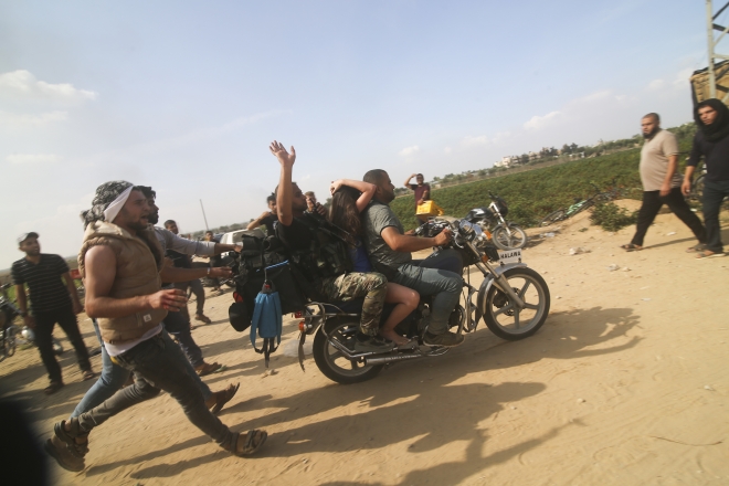 7일(현지시간) 이스라엘 남부에 침투한 팔레스타인 무장세력이 크파르 아자 키부츠에서 납치한 이스라엘 민간인을 오토바이에 태워 가자지구로 끌고 가고 있다. 2023.10.7 AP 연합뉴스