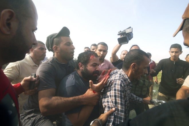 7일(현지시간) 팔레스타인인들이 붙잡힌 이스라엘 시민(가운데)을 가자지구로 이송하고 있다. 2023.10.7.  AP 연합뉴스