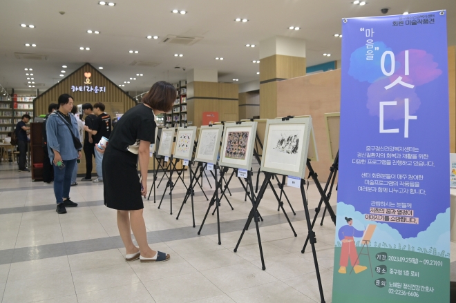 관람객들이 지난달 25일 서울 중구 정신건강복지센터가 중구청 로비에서 연 ‘마음을 잇다’ 전시회를 보고 있다. 중구 제공