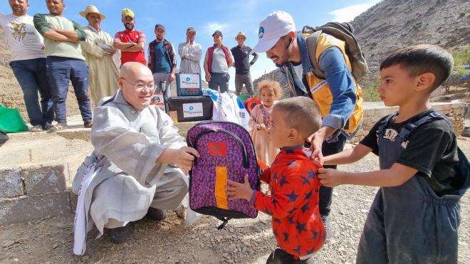 대한불교조계종사회복지재단 대표이사 묘장 스님이 모로코 현지 아이들에게 가방을 건네고 있다. 조계종사회복지재단 제공