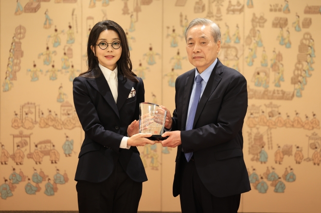 윤석열 대통령 부인 김건희 여사가 12일 서울 용산 대통령실 청사에서 열린 대한암협회 명예회장 추대행사에서 이민혁 대한암협회 회장으로부터 추대패를 받은 뒤 기념촬영을 하고 있다. 대통령실 제공