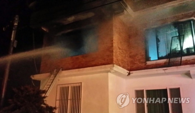 방화로 불 타고 있는 박씨 집에 소방대원들이 물을 뿌리고 있다. 집 안에 있던 일가족 4명이 모두 숨졌다.