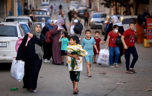 팔레스타인 여성들과 어린이들이 13일(현지시간) 가자지구 중심 도시 가자시티에서 짐을 챙겨 더 안전한 지역으로 피신하고 있다. 이스라엘은 팔레스타인 무장 정파 하마스와의 무력 충돌 이레째인 이날 가자시티 주민 전원에게 대피령을 내렸다. 연합뉴스
