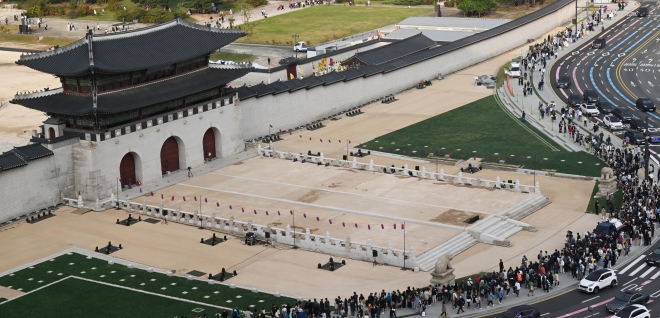 광화문 월대 및 현판 복원 기념식을 앞둔 15일 서울 종로구 광화문 월대 복원 공사 현장 인근에서 시민들이 이동하고 있다.  홍윤기 기자