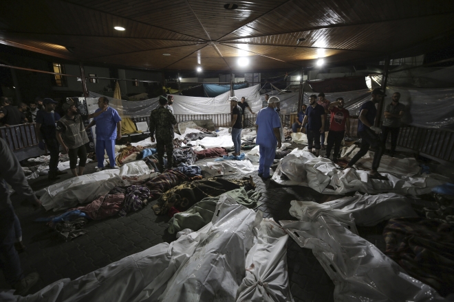 17일(현지시간) 팔레스타인 가자지구 가자시티의 알 시파 병원 앞마당에 같은날 알아흘리 병원 폭발로 사망한 팔레스타인 사람들의 시신이 모여 있다. 2023.10.17 AP 연합뉴스