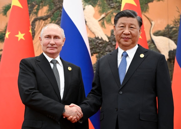 시진핑(오른쪽) 중국 국가주석과 블라디미르 푸틴 러시아 대통령이 18일 베이징 인민대회당에서 정상회담을 갖기 전 악수하고 있다. 두 정상은 ‘반미연대’ 강화와 이스라엘·하마스 해법 등을 논의했다. 베이징 타스 연합뉴스