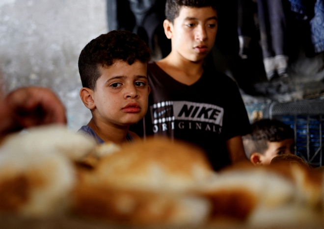 장작으로 구운 빵 바라보는 팔레스타인 어린이