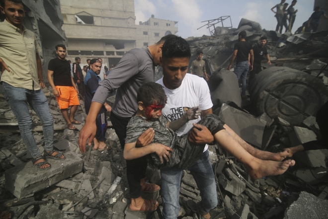 22일(현지시간) 이스라엘군의 공습을 받은 팔레스타인 가자지구의 한 건물에서 부상당한 어린이가 들려나오고 있다. 2023.10.22 AP 연합뉴스