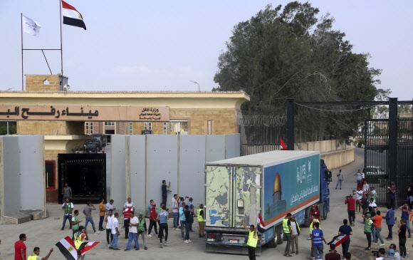 가자지구 주민들에게 전달하려는 인도주의적 구호 물품을 실은 트럭 한 대가 22일(현지시간) 이집트 라파 국경 검문소를 통과해 가자지구 쪽으로 향하고 있다. 전날 20대가 가자지구로 진입한 데 이어 이날도  17대가 통과했다. 유엔은 이 ‘생명길’을 통해 반입되는 구호품 물량이 매일 트럭 100대 정도는 되어야 한다고 촉구하고 있다. 라파 AP 연합뉴스