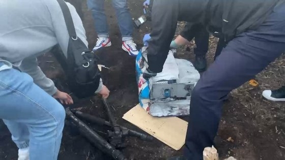 지난 21일 택시기사 여동생의 과수원을 수색해 파묻은 이동식 단속카메라를 찾아내고 있다. 서귀포경찰서 제공