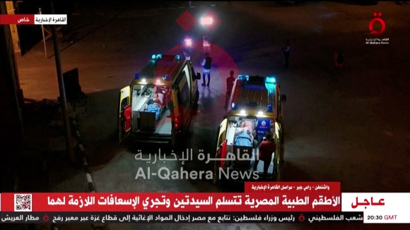 누릿 쿠퍼와 요체베드 리프시츠가  23일(현지시간) 앰뷸런스에 실려 가자지구 남부와 이집트를 연결하는 라파 국경 검문소를 통해 이집트 쪽으로 향하고 있다. 알카히라 뉴스 영상 캡처 로이터 연합뉴스