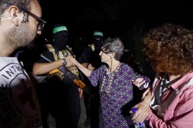 23일(현지시간) 하마스의 손아귀에서 풀려난 이스라엘 여성 인질 요체베드 리프시츠가 하마스 대원에게 손을 내밀자 맞잡고 있다. 알카삼 여단 동영상 캡처 AP
