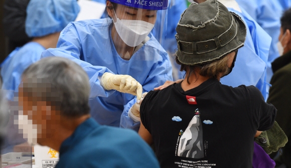 서울시는 다음 달 3일까지 노숙인과 쪽방주민을 대상으로 무료 독감 예방접종을 실시한다. 지난 2021년 영등포 보현동합지원센터에서 시민들이 독감 예방접종을 하고 있다. 2021.11.16 서울신문 DB