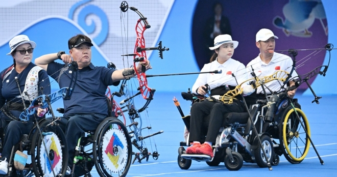 한국 양궁 국가대표 김옥금-박홍조가 26일 중국 항저우 푸인인후 스포츠센터에서 열린 2022 항저우아시안패러게임 혼성 W1 복식 중국과의 결승전에서 활을 쏘고 있다. 대한장애인체육회 제공