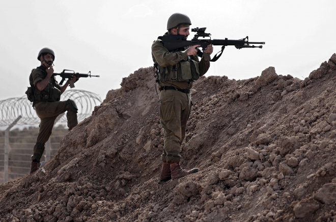 22일(현지시간) 이스라엘이 주최한 미디어 투어에서 찍힌 사진. 이스라엘 군인들이 비에리 키부츠에서 가자지구 국경을 따라 방어진지를 구축하고 있다. 2023.10.22. AFP 연합뉴스