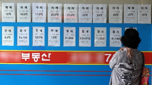 한 시민이 서울 송파구에 있는 부동산 중개사무소에 붙은 매물 가격표를 살펴보고 있다. 뉴스1