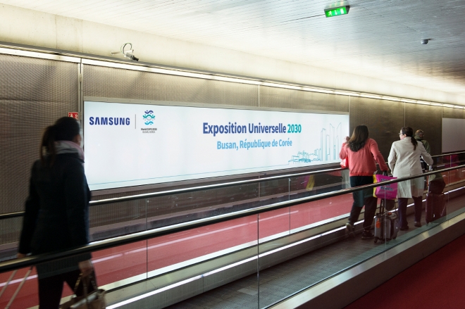 프랑스 파리 샤를드골국제공항 입국장 이용객이 삼성전자의 ‘2030 부산엑스포 광고판’ 앞을 지나고 있다.  삼성전자 제공