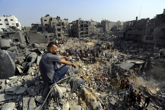 한 남성이 지난 1일(현지시간) 팔레스타인 가자지구 안 자발리아 난민촌에서 이스라엘군의 포격으로 무너진 잔해에 깔린 생존자들을 찾는 이들을 황망한 표정으로 바라보고 있다. 자발리아 AP 연합뉴스