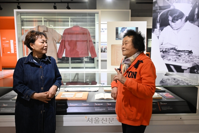 1960·1970년대 구로공단에서 여공으로 일했던 강명자(왼쪽)씨와 조창엽씨가 지난달 20일 서울 구로구 G밸리산업박물관에서 옛날 작업복 등을 보며 이야기를 나누고 있다. 도준석 기자