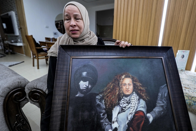 이스라엘군이 6일(현지시간) 팔레스타인 자치치구인 요르단강 서안 나비살레 마을에서 팔레스타인 운동가 아헤드 타미미(22)를 체포한 가운데, 이날 타미미의 모친 나리만 타미미가 자택에서 딸의 얼굴이 그려진 그림 액자를 들고 인터뷰에 응하고 있다. 2023.11.7 AFP 연합뉴스