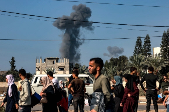 9일(현지시간) 가자시티와 가자지구 북부의 다른 지역을 빠져나와 남쪽으로 피신하는 주민들 뒤로 이스라엘군의 공습 때문에 생긴 연기가 피어오르고 있다. 가자시티 AFP 연합뉴스