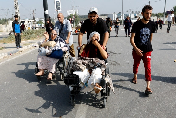 이스라엘군의 공습에 다쳐 팔레스타인 가자지구 알시파 병원에서 치료를 받던 여성들이 10일(현지시간) 병원이 이스라엘 탱크에까지 포위되자 남쪽으로 피신하고 있다. 가자시티 로이터 연합뉴스