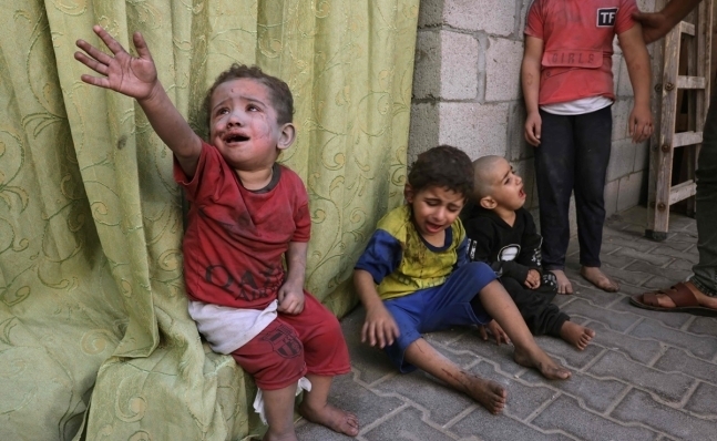 지난 23일 가자지구 남부 라파의 한 병원에 이스라엘 공습으로 먼지를 뒤집어 쓴 팔레스타인 어린이들이 앉아있다. AFP 연합뉴스