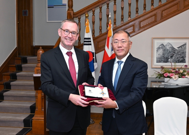 정의선(오른쪽) 현대자동차그룹 회장이 지난 14일 서울 중구 주한영국대사관에서 열린 대영제국 훈장 수훈식에서 콜린 크룩스 주한 영국대사와 함께 ‘대영제국 지휘관 훈장’을 들어 보이고 있다. 뉴시스