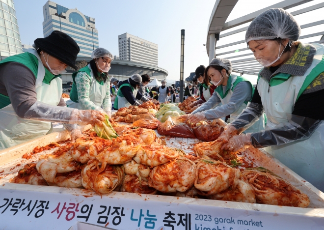 15일 서울 송파구 가락동 가락몰 하늘공원에서 열린 ‘2023 가락시장 사랑의 김장나눔’ 행사에 참가한 상인과 자원봉사자들이 김치를 담그고 있다. 이날 담근 김치를 비롯한 약 8만 포기의 김치는 취약계층과 복지시설·단체 등 어려운 이웃에게 전달된다. 뉴스1