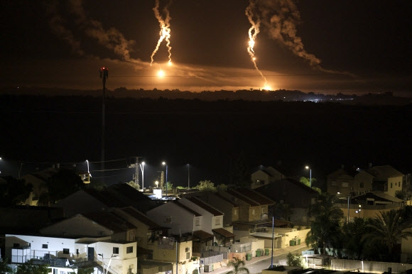 팔레스타인 가자지구의 밤하늘에 화염이 치솟고 있는 것이 16일(현지시간) 평화롭게 잠든 이스라엘 남부 주택가에서 보이고 있다. AP 연합뉴스