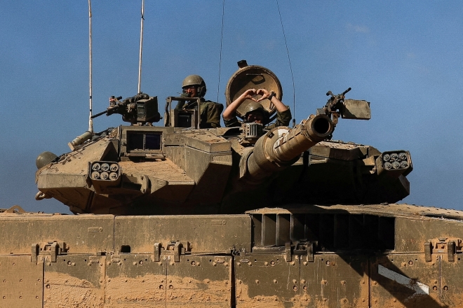 17일(현지시간) 이스라엘 남부의 가자지구 간 국경에서 한 이스라엘 병사가 탱크 위에서 손짓을 하고 있다. 2023.11.18  로이터 연합뉴스