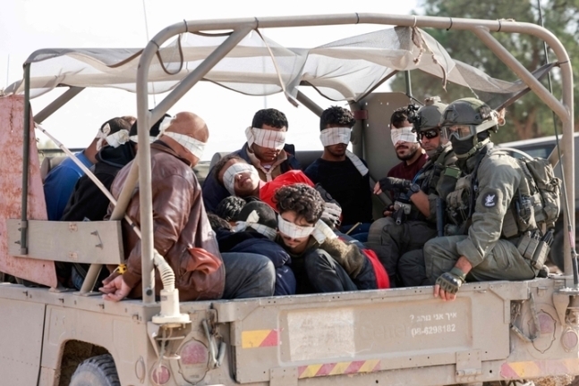 이스라엘 군인들이 21일(현지시간) 억류된 팔레스타인인들을 가자지구 밖으로 이송하고 있다. AFP 연합뉴스