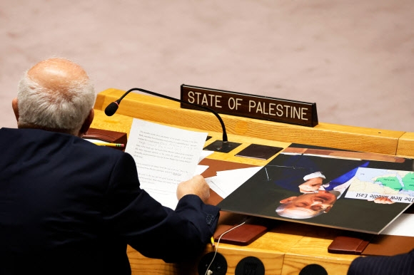 리야드 H 만수르 유엔 팔레스타인 영구 감독관이 22일 미국 뉴욕 유엔본부의 안전보장이사회 회의에 참석하는데 그의 테이블 위에 베냐민 네타냐후 이스라엘 총리 사진이 놓여 있다. 뉴욕 AFP 연합뉴스
