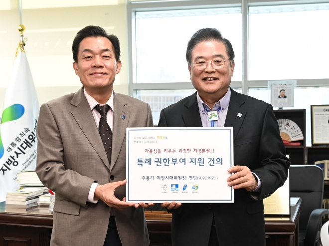 이재준 수원시장(왼쪽)이 우동기 지방시대위원장에게 건의문을 전달하고 있다. 수원시 제공