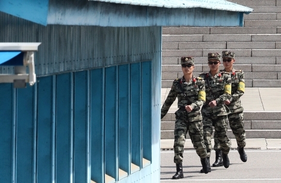 북측 경비군인 3명이 군사분계선(MDL) 북쪽에 있는 판문각을 나와 근무지로 이동하고 있다. 판문점 사진공동취재단