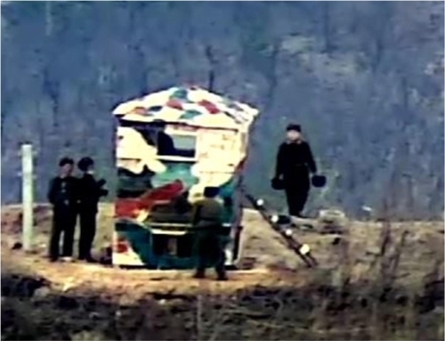 국방부는 지난 24일 북한이 동부전선 최전방 소초(GP)에서 감시소를 복원하는 정황을 지상 촬영 장비와 열상감시장비(TOD) 등으로 포착했다고 27일 밝혔다. 사진은 북한군이 목재로 구조물을 만들고 얼룩무늬로 도색하는 모습.  국방부 제공