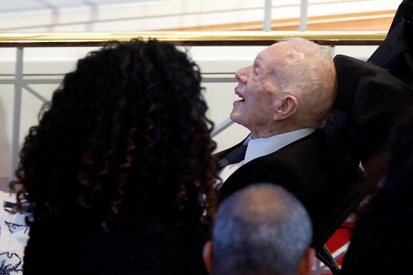 지미 카터 전 미국 대통령이 28일(현지시간) 조지아주 애틀랜타의 에머리 대학 구내 글렌 메모리얼 교회에서 엄수된 부인 로절린 카터의 장례식 도중 휠체어에 앉은 채로 고인의 마지막을 배웅하고 있다. 애틀랜타 로이터 연합뉴스