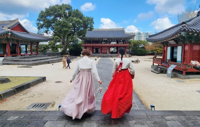 제주 목관아를 찾은 중국 MZ세대 개별 여행객들이 한복을 곱게 차려입고 관광하고 있다. 연합뉴스