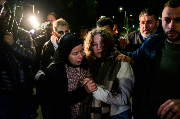 ‘팔레스타인의 잔다르크’로 불리는 아메드 타미미(가운데 오른쪽)가 일시 휴전 엿새째인 29일(현지시간) 밤 늦게 풀려나 요르단강 서안지구 라말라에 도착하자 친척을 비롯해 많은 이들이 반기고 있다. 라말라 AFP 연합뉴스