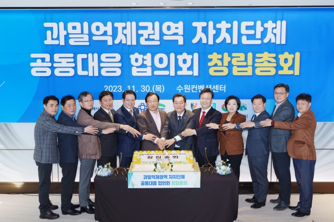 과밀억제권역 자치단체 공동대응협의회 대표회장으로 선출된 이재준(오른쪽 여섯 번째) 수원시장을 비롯한 12개 단체 시장, 부시장, 국장 등이 기념촬영을 하고 있다. 수원시 제공