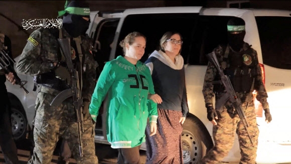 일시 휴전 이레째인 30일(현지시간) 팔레스타인 무장정파 하마스가 석방한 이스라엘 여성 인질들이 국제적십자사(ICRC)에 인계되기 위해 차량에서 내려 이동하고 있다. 하마스 군사조직 제공 로이터 연합뉴스