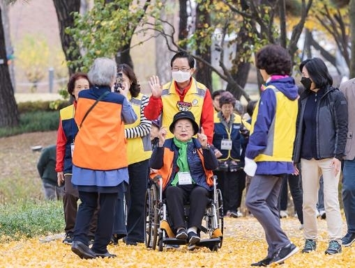 최호권(가운데) 영등포구청장이 지난달 ‘자원봉사 Day’ 활동에 참여해 거동이 불편한 어르신의 휠체어를 밀며 나들이에 동행하고 있다. 영등포구 제공