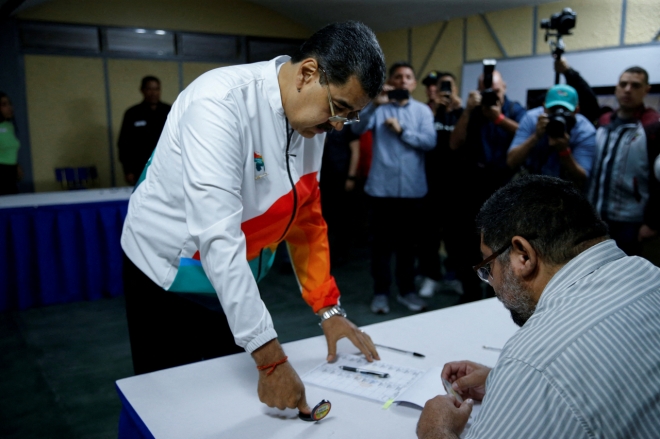 니콜라스 마두로 베네수엘라 대통령이 3일(현지시간) 수도 카라카스의 한 투표장에서 풍부한 양질의 천연자원을 품은 가이아나 서쪽 영토를 자국으로 편입시키기 위한 국민투표에 참여하고 있다.  카라카스 로이터 연합뉴스